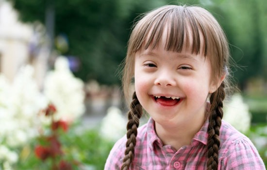 Young girl with down syndrome smiles for a picture