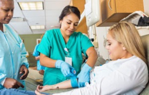female nurse draws blood of patient