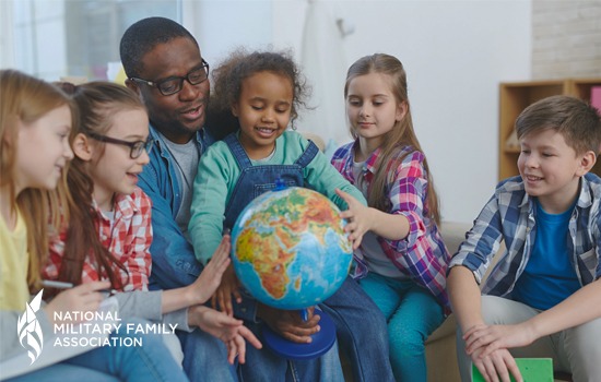 Teacher and students sit around a globe