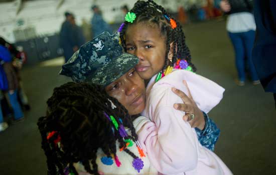 service-member-mom-with-kids Service member and her young daughters cry before deployment