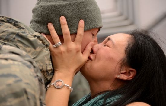 Service member kisses spouse reuniting after deployment