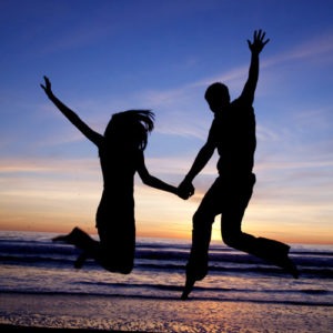 Couple jumping on the beach